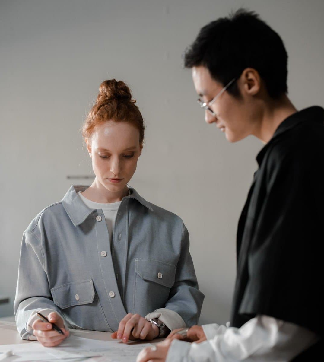Two lighting designers reviewing drawings together at a studio workbench